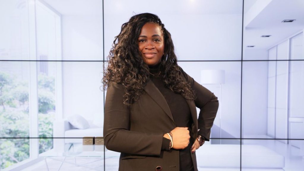 Portrait d'une entrepreneure confiante, partageant son témoignage inspirant sur la formation Plus Jamais Fauché, intitulé 'Une source d'encouragement'.