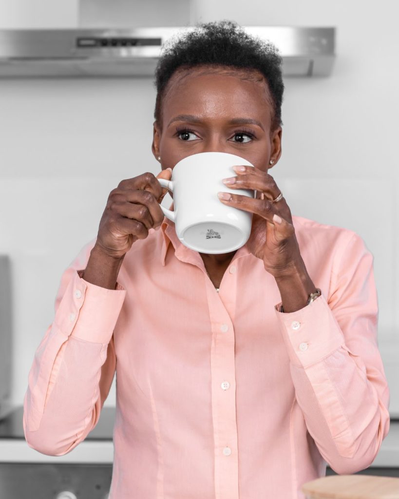 Consultante financière buvant un café, symbolisant la réflexion stratégique et le calme nécessaire pour créer un business plan efficace.